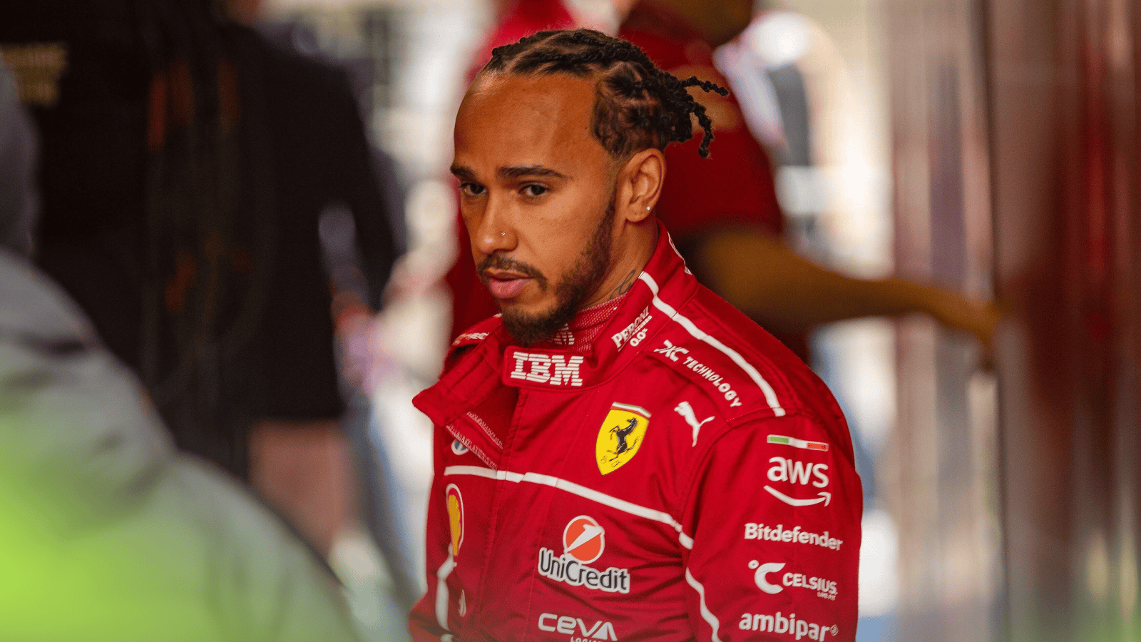 Lewis Hamilton stood wearing Ferrari overalls