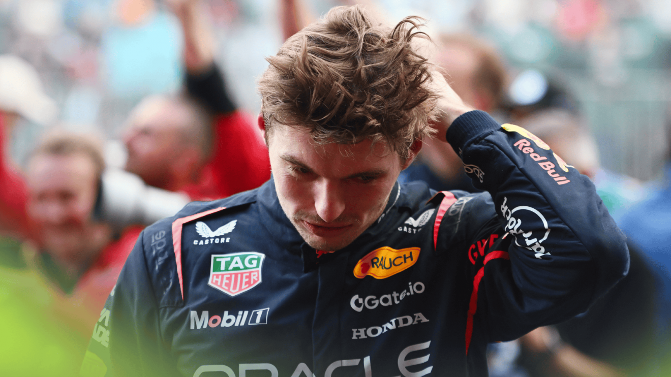 Max Verstappen looks down as he runs his hands through his air in parc ferme