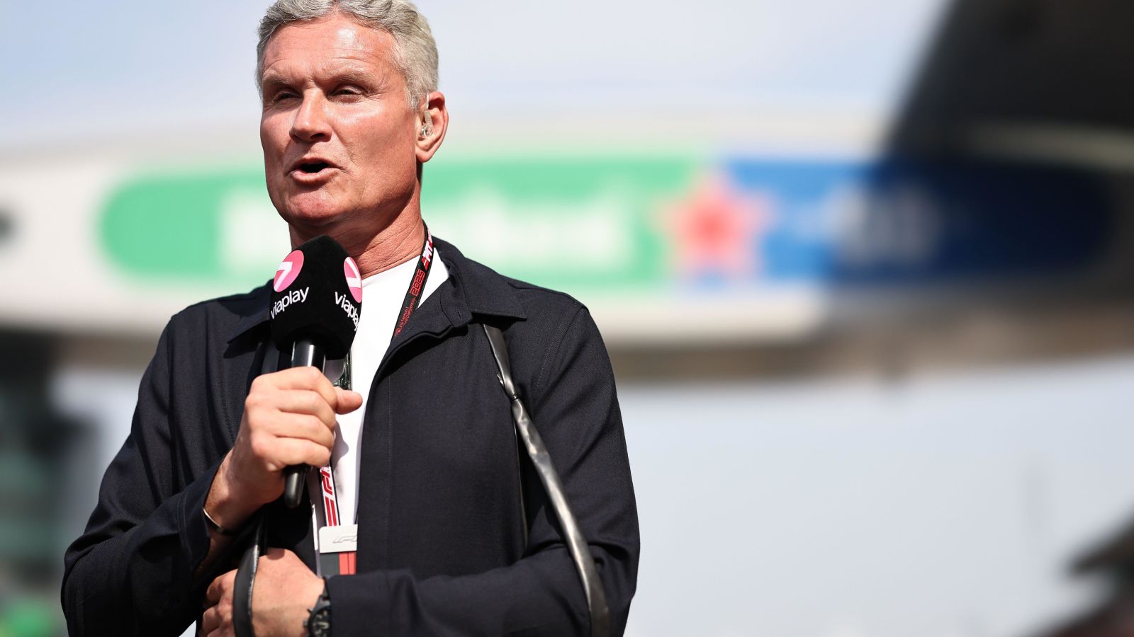 David Coulthard with his left arm in a sling at the 2025 Chinese Grand Prix after a motorbike crash in New Zealand