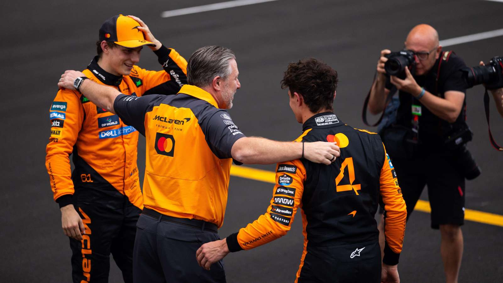 McLaren drivers Oscar Piastri and Lando Norris are congratulated by Zak Brown.