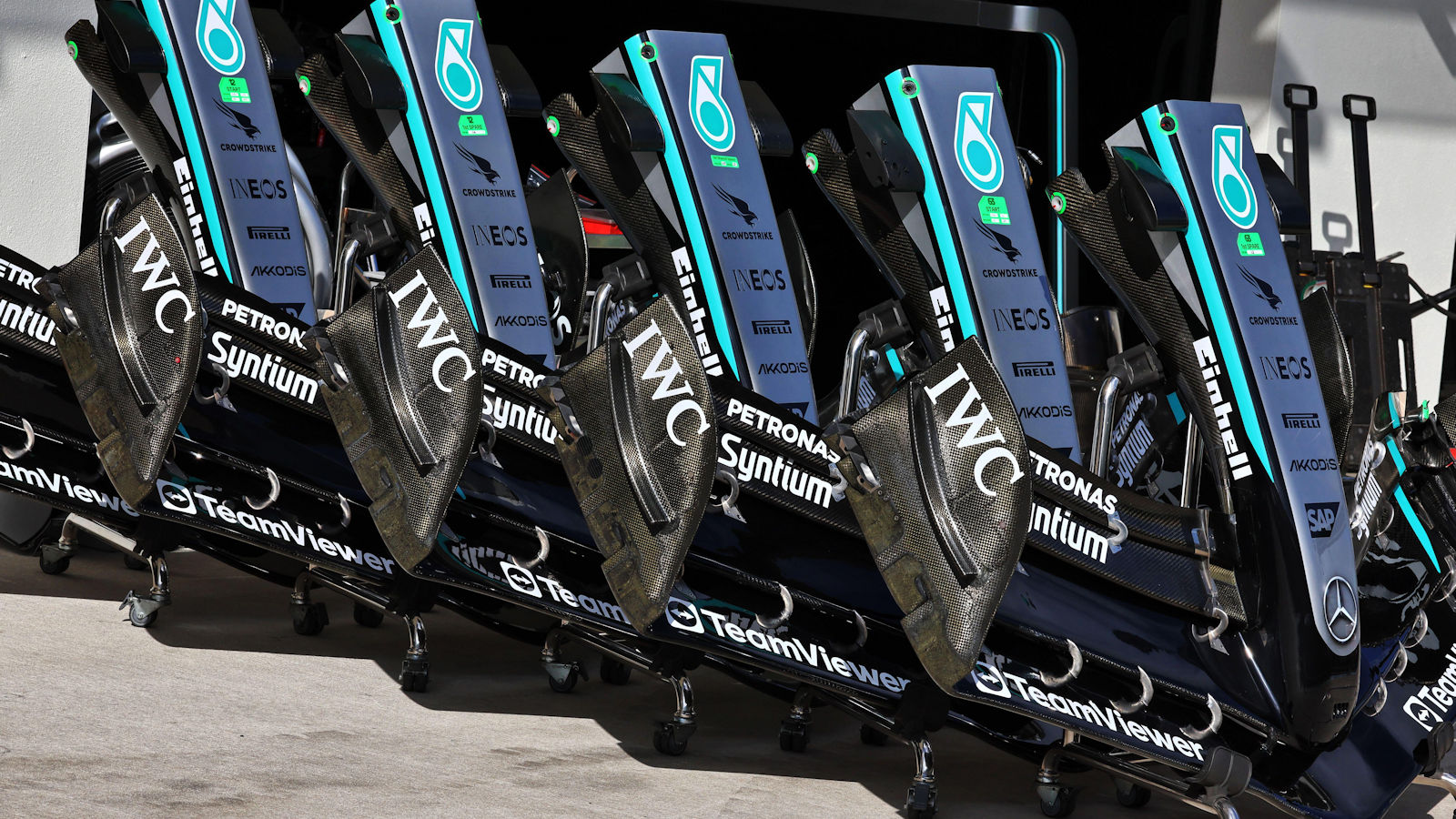 A row of front wing and nose assemblies stacked up outside the Mercedes garage