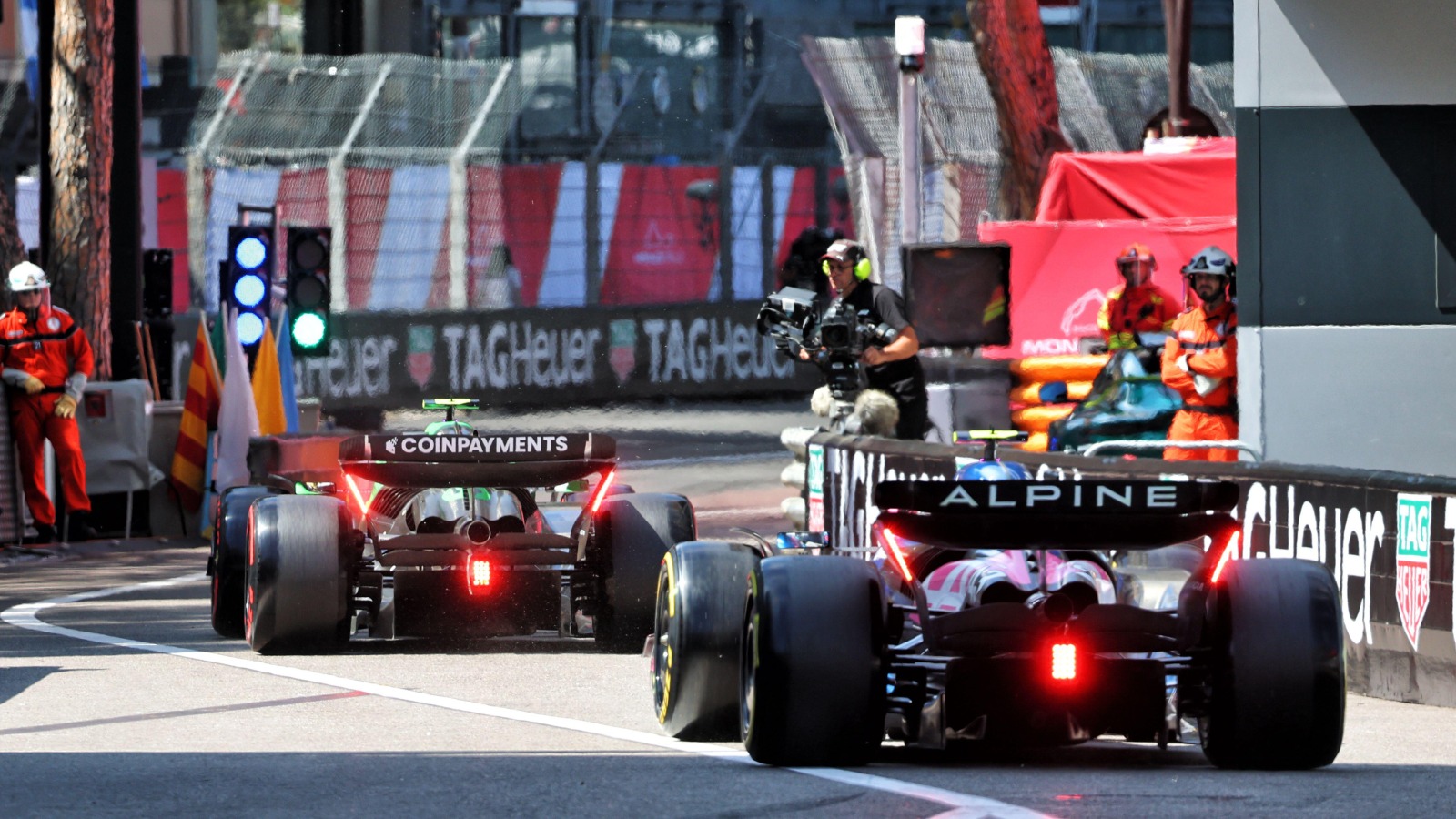 A Sauber leaves an Alpine down the pit lane and out onto the track during the Monaco Grand Prix.