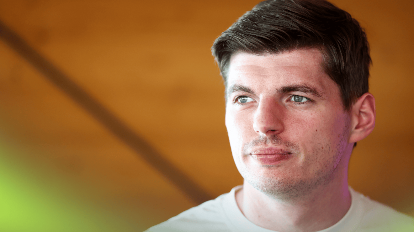 Max Verstappen looking into the distance while wearing a plain-white t-shirt