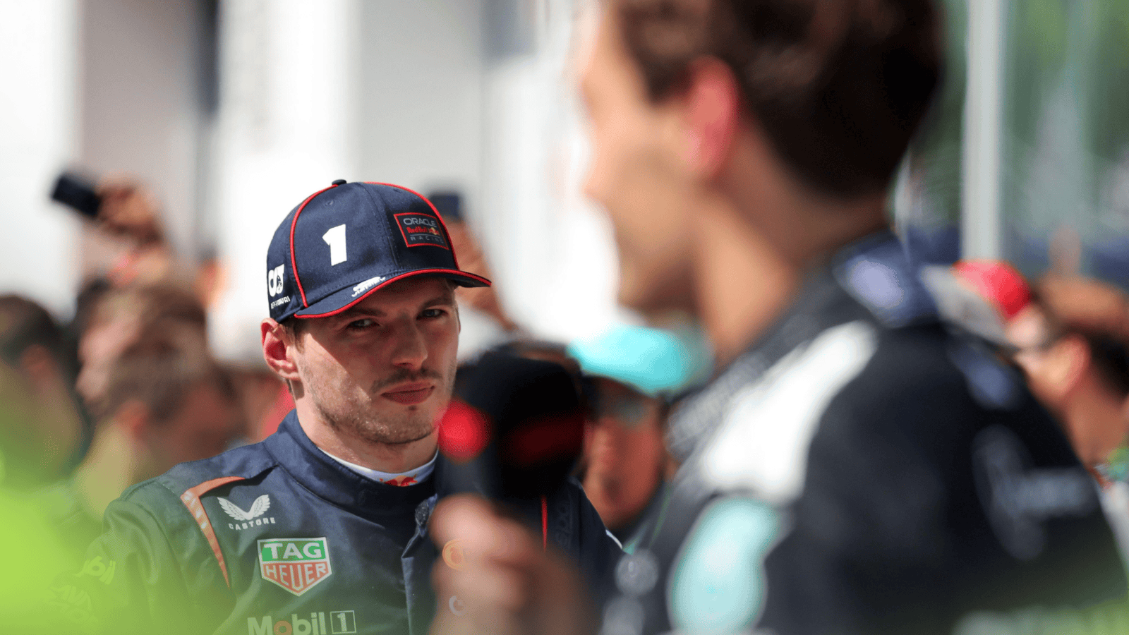 Max Verstappen looks on as George Russell speaks to the media in Canada