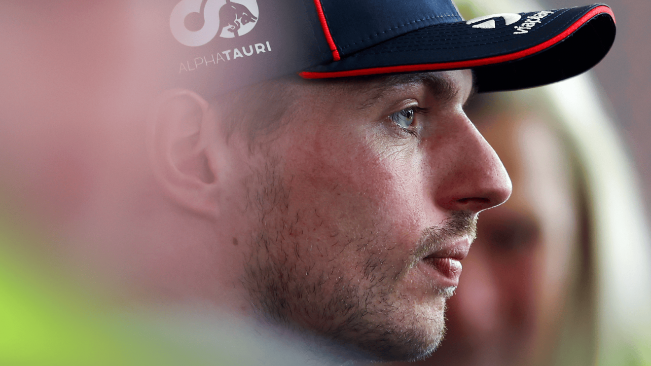 A side-profile shot of Max Verstappen facing the media