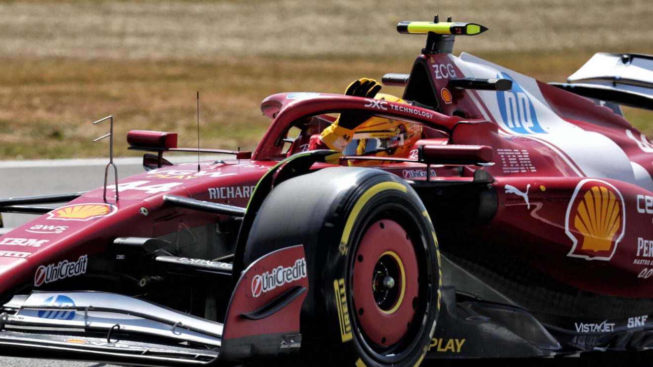 Lewis Hamilton waves at the crowd from the cockpit of his Ferrari