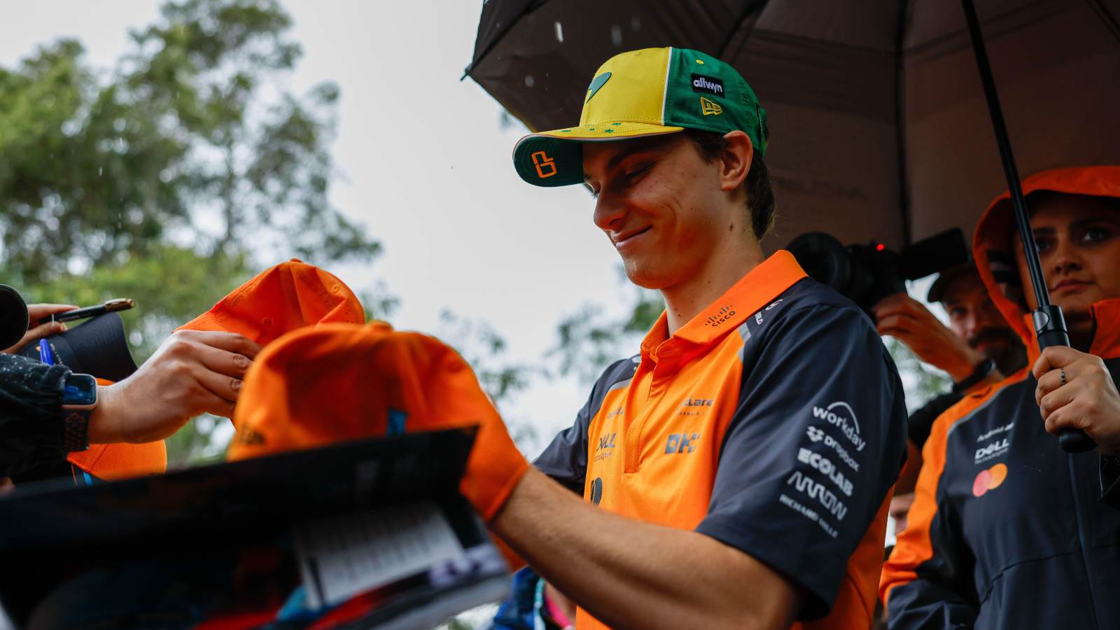Oscar Piastri signs merchandise at the Australian GP.