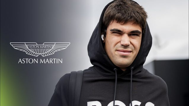 Lance Stroll pictured in the 2025 Dutch Grand Prix paddock, as the Aston Martin logo appears on his left