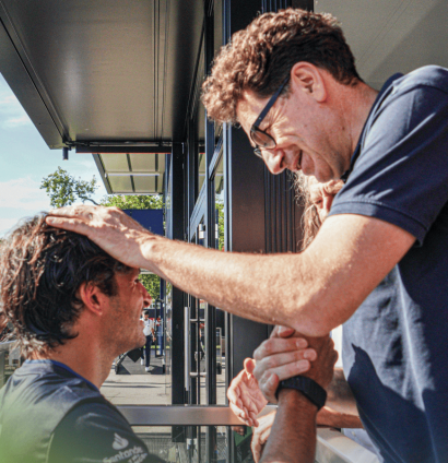 Mattia Binotto ruffles Carlos Sainz's hair in the paddock at Monza