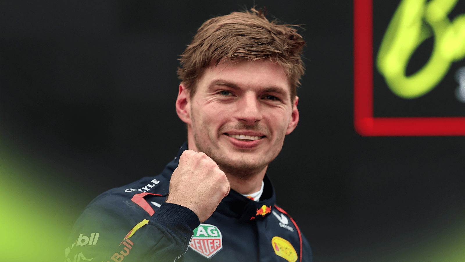 Max Verstappen smiles and punches the air as he eyes the camera in parc ferme