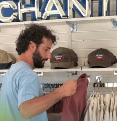 Daniel Ricciardo handling clothing at an Enchance pop-up store in Austin, Texas