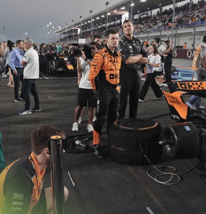 Adrian Newey studies the McLaren MCL39 on the grid in Qatar as a group of McLaren mechanics look on