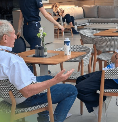 Helmut Marko and Liam Lawson sat at a table in discussion in the Qatar Grand Prix paddock