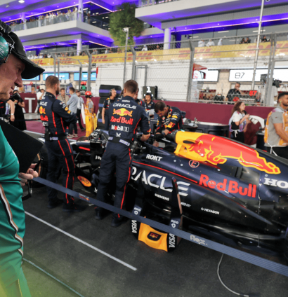 Adrian Newey stands next to Max Verstappen's Red Bull RB21 on the grid at the 2025 Qatar Grand Prix