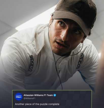 Carlos Sainz in a cap and plain-white race suit with a Williams tweet and PlanetF1.com logo positioned centre-bottom