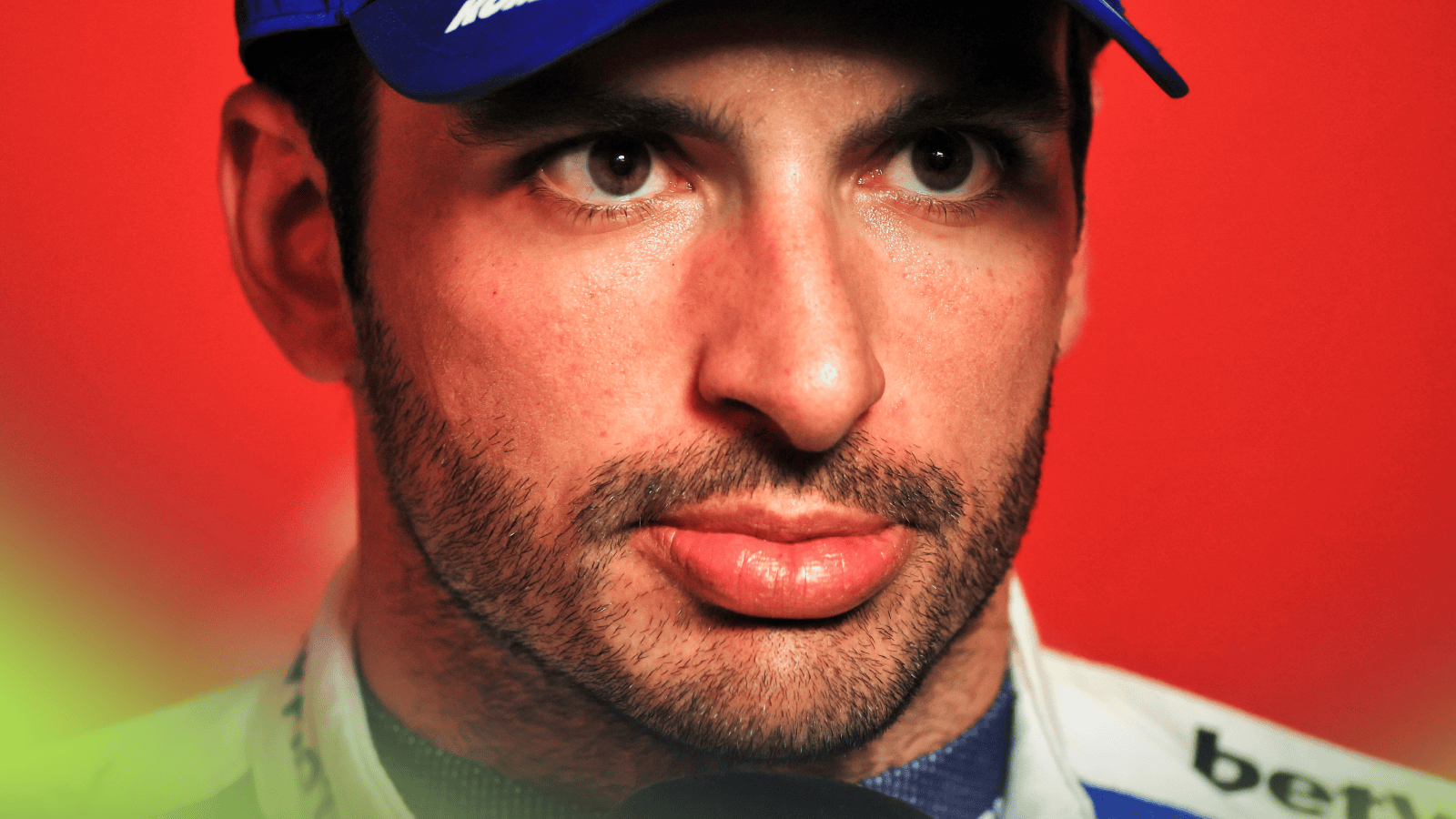 A close-up shot of Carlos Sainz against a red background