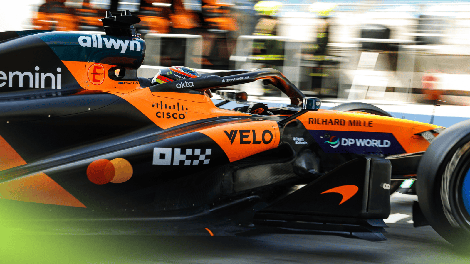 Oscar Piastri pulls out of the garage in the Bahrain pit lane with the McLaren put wall in the background