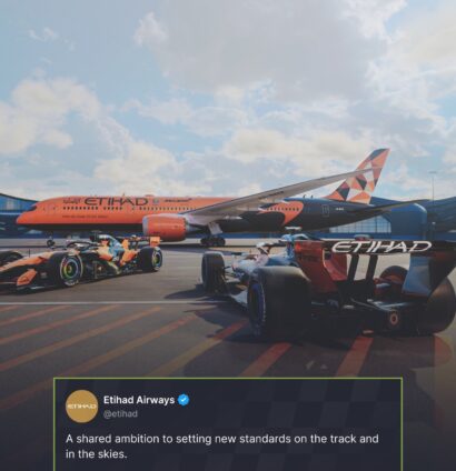 Two McLaren F1 cars with a McLaren-branded Etihad Airways plane in the background