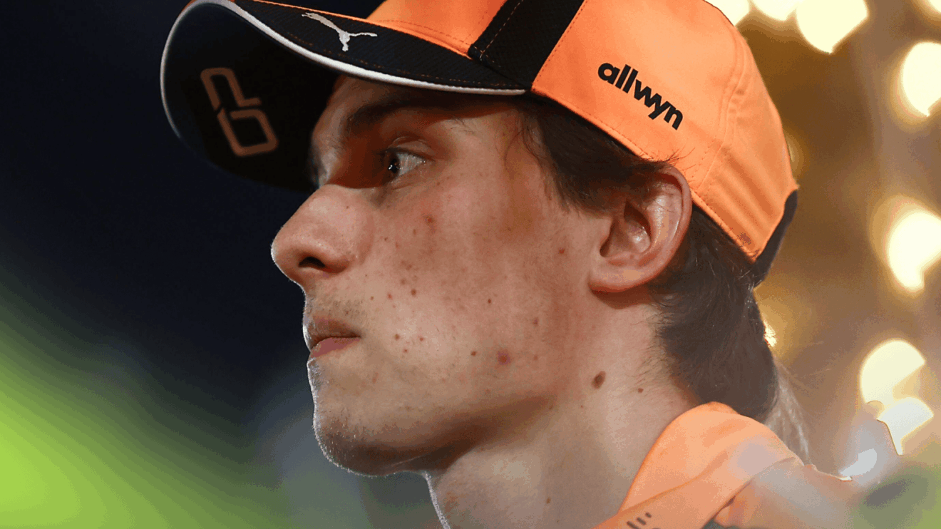 A side-profile shot of Oscar Piastri at night in the Bahrain paddock