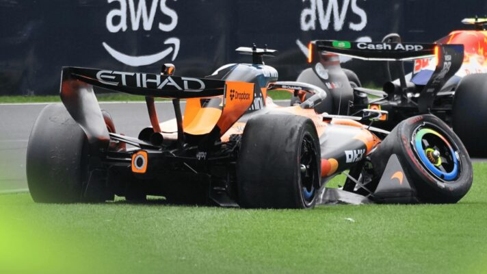 A rear-view shot of Oscar Piastri's McLaren on the grass with severe damage