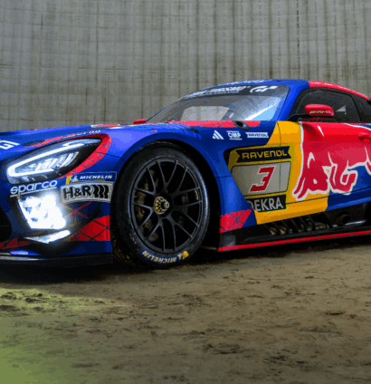 A Red Bull-branded Mercedes AMG GT3 car sitting on sand