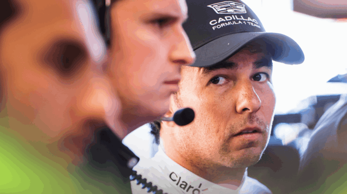 Sergio Perez glances at a couple of Cadillac engineers stood beside him in the garage