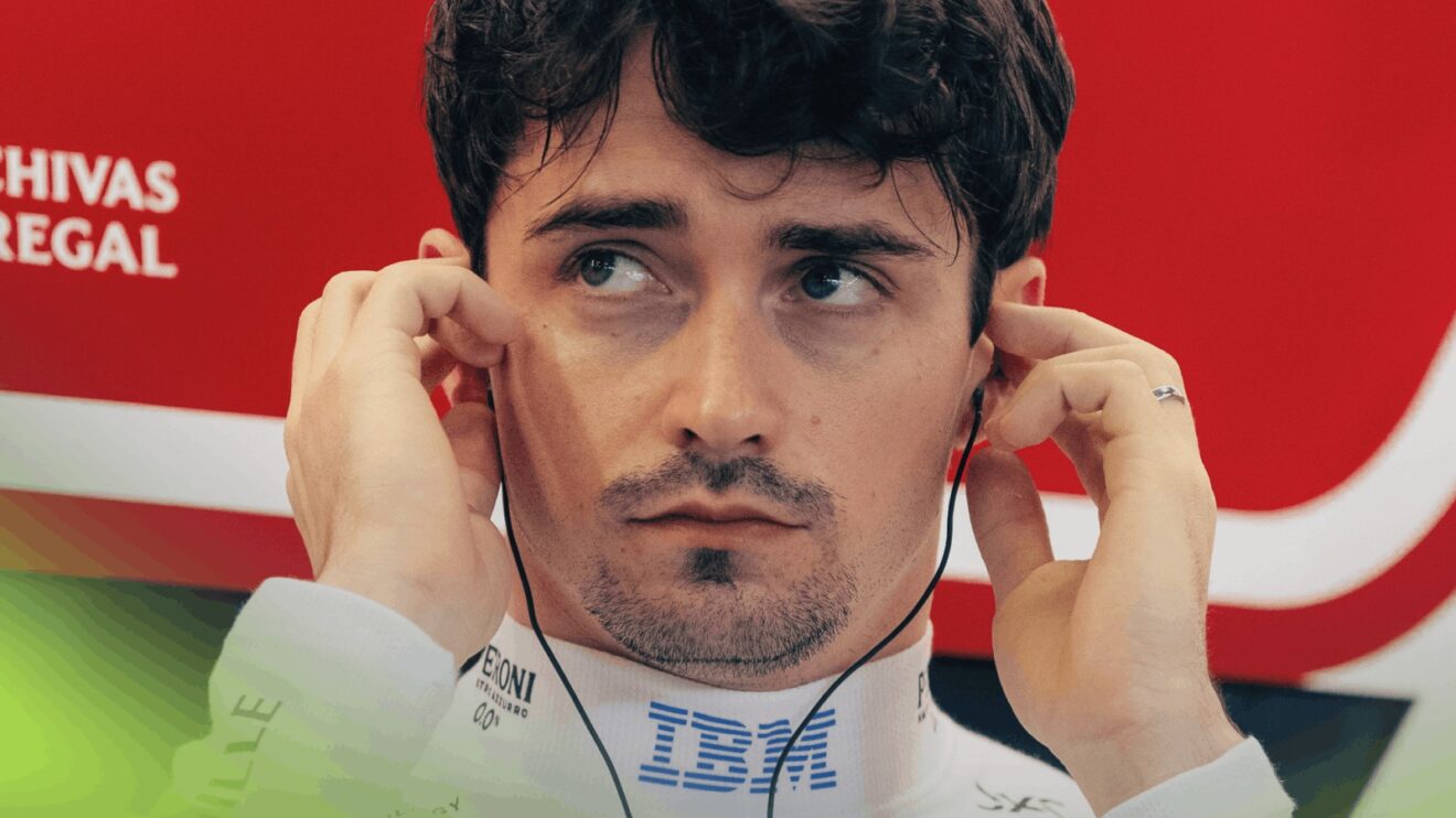 A close-up shot of Charles Leclerc inserting his earplugs in the Ferrari garage
