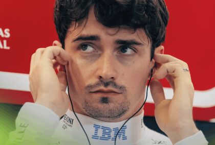 A close-up shot of Charles Leclerc inserting his earplugs in the Ferrari garage