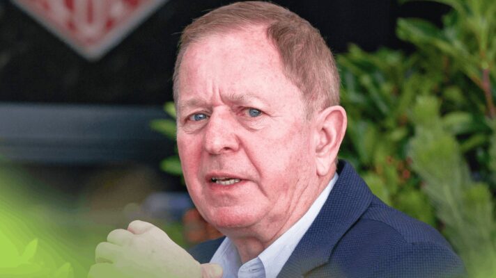 Martin Brundle eyes the camera while in conversation in the paddock