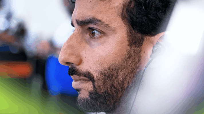 A side-profile, close-up shot of Daniel Ricciardo in the Racing Bulls garage