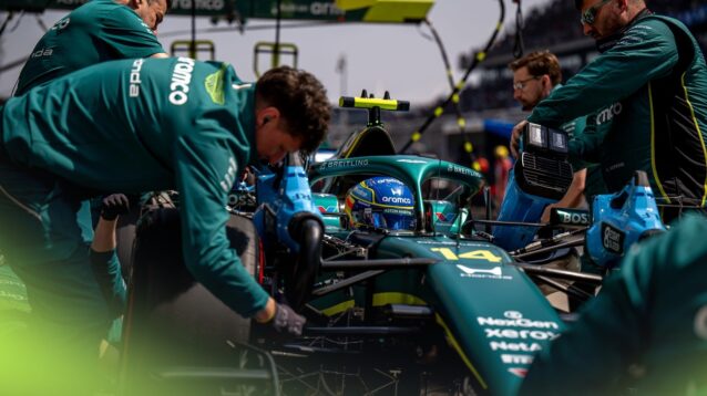 Fernando Alonso is serviced by Aston Martin mechanics in the pit lane in China.