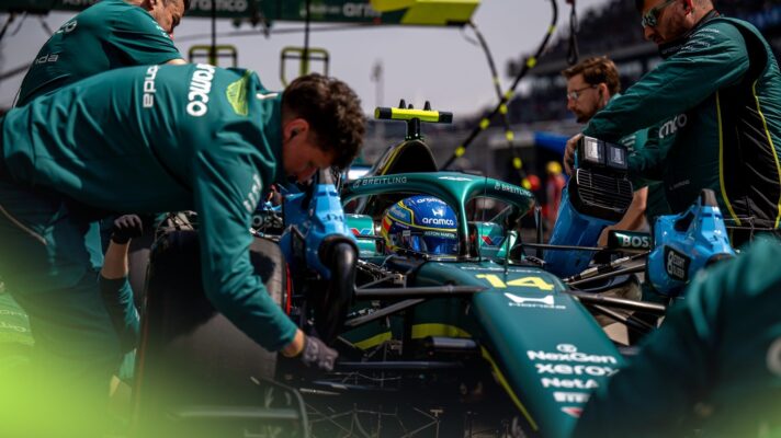Fernando Alonso is serviced by Aston Martin mechanics in the pit lane in China.