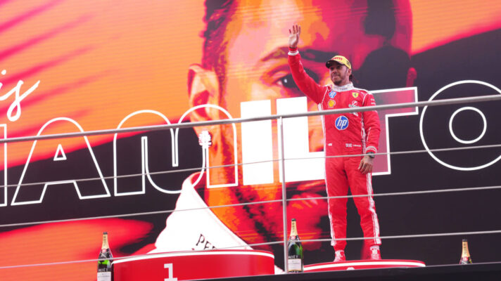 Lewis Hamilton stands on the podium for the first time as a Ferrari driver