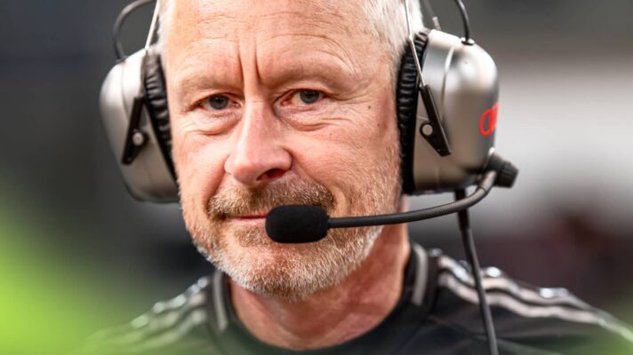 A close-up shot of Jonathan Wheatley wearing a set of Audi F1 headphones