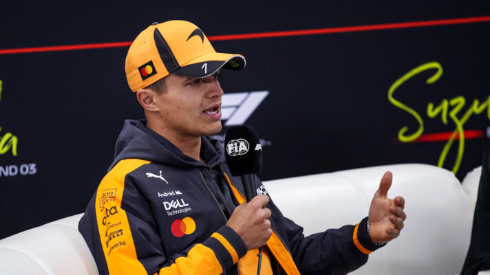 Lando Norris gestures in a press conference