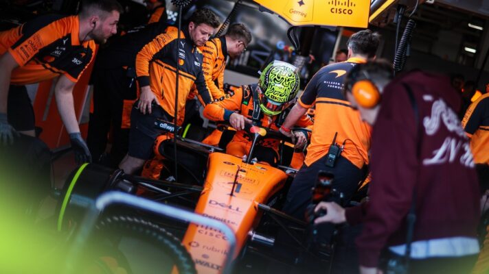 Lando Norris climbs into his McLaren MCL40 in the garage.