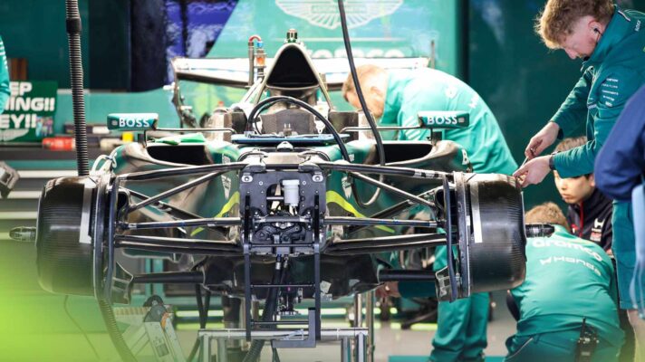 Aston Martin mechanics work on the AMR26 in the team's garage at Suzuka.
