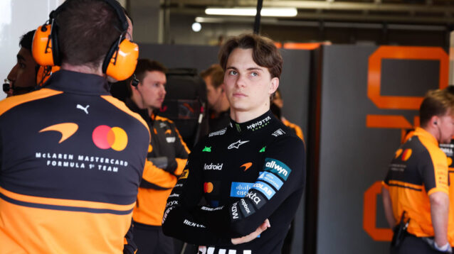 Oscar Piastri with his arms folded in the McLaren garage