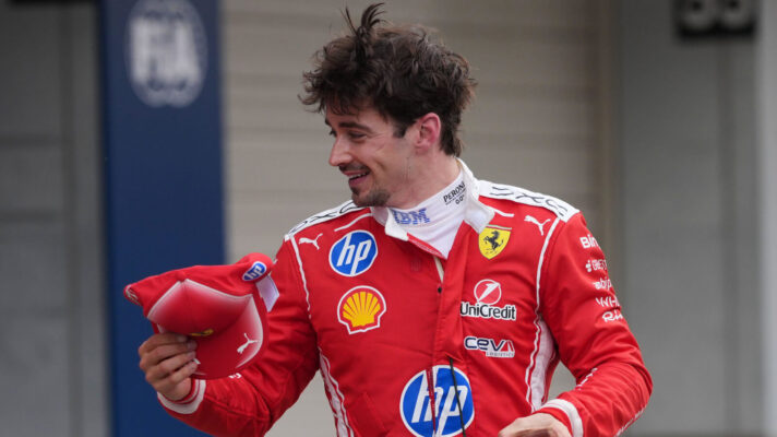 Charles Leclerc laughing with a cap in his hand