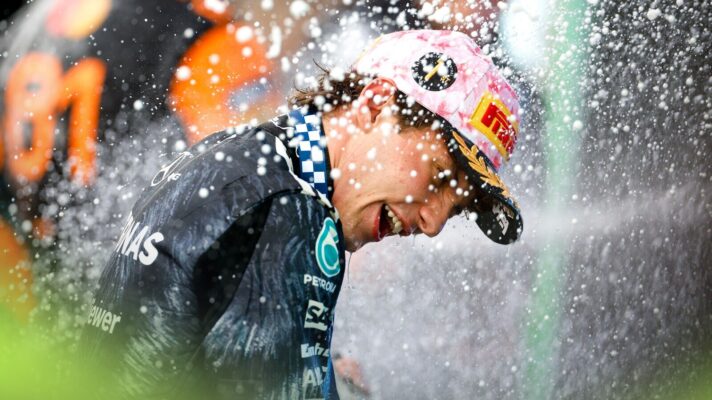 Kimi Antonelli smiles as he turns away from the champagne spray in the podium as he celebrates victory in the Japanese Grand Prix.