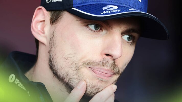 A close-up shot of Max Verstappen holding his hand to his chin