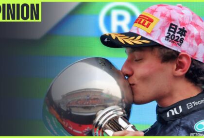 Kimi Antonelli kisses the winners' trophy on the podium with an 'opinion' tab in the top-left corner