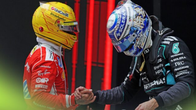 Lewis Hamilton and George Russell shake hands with the helmets on in parc ferme after climbing out of their cars.