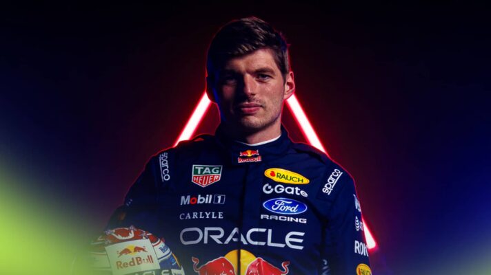 Max Verstappen poses in Red Bull 2026 overalls while clutching his crash helmet