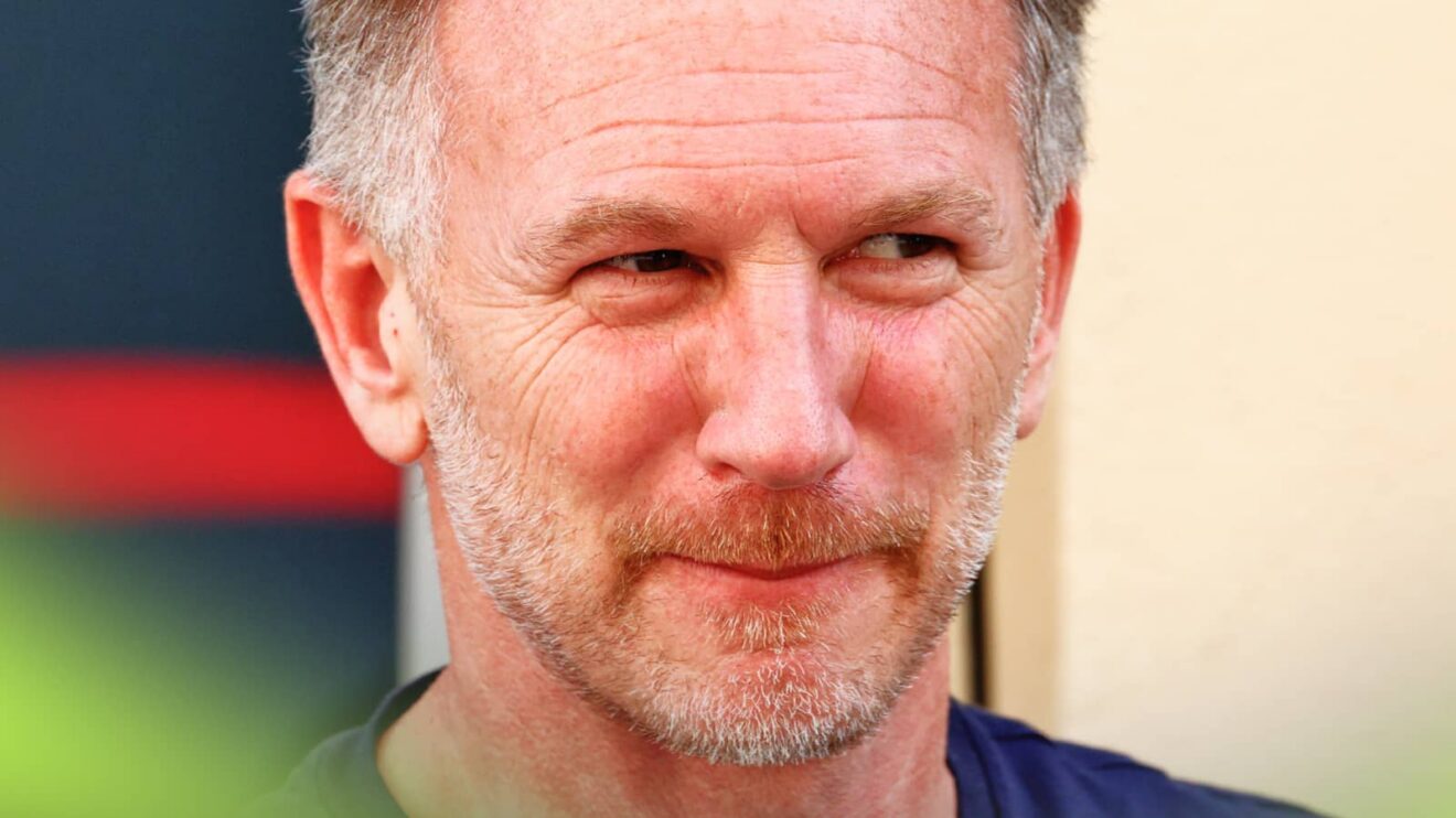 A close-up shot of Christian Horner glancing to his left in the paddock