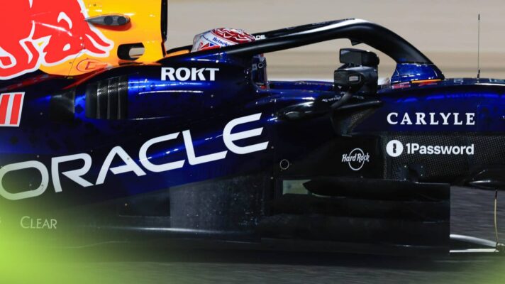 A side-profile shot of Max Verstappen at the wheel of the Red Bull RB22 at night in Bahrain