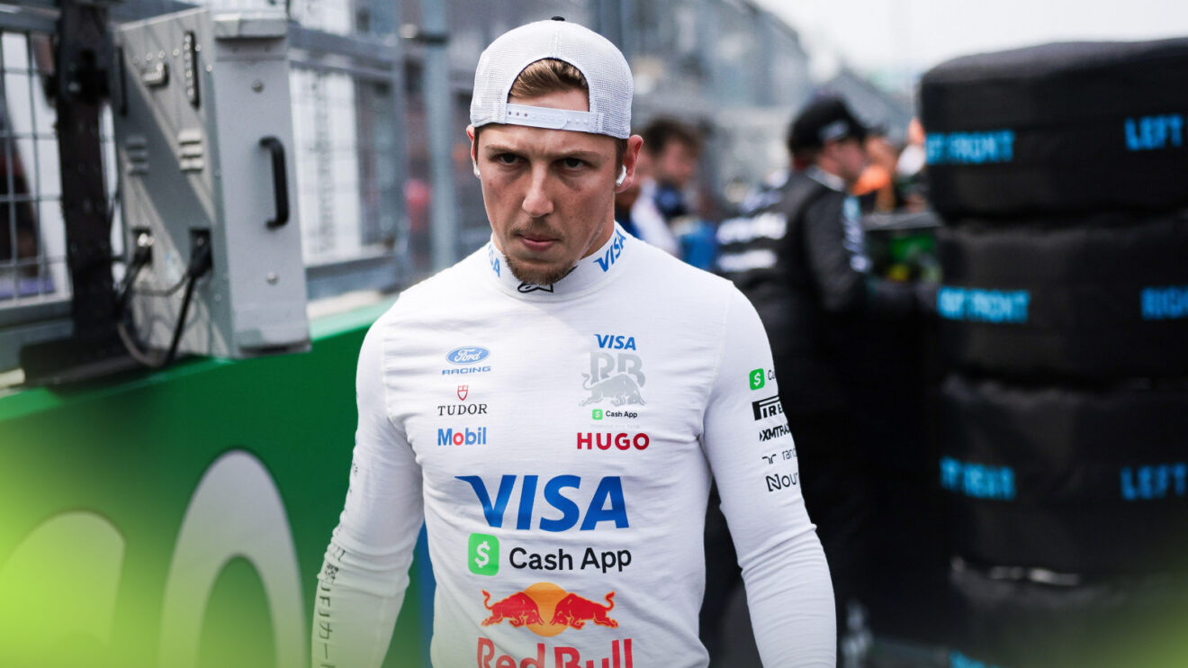 A serious looking Liam Lawson walks down the grid ahead of a grand prix.