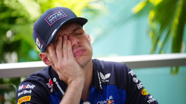 An exasperated looking Max Verstappen holds his hand to his face.
