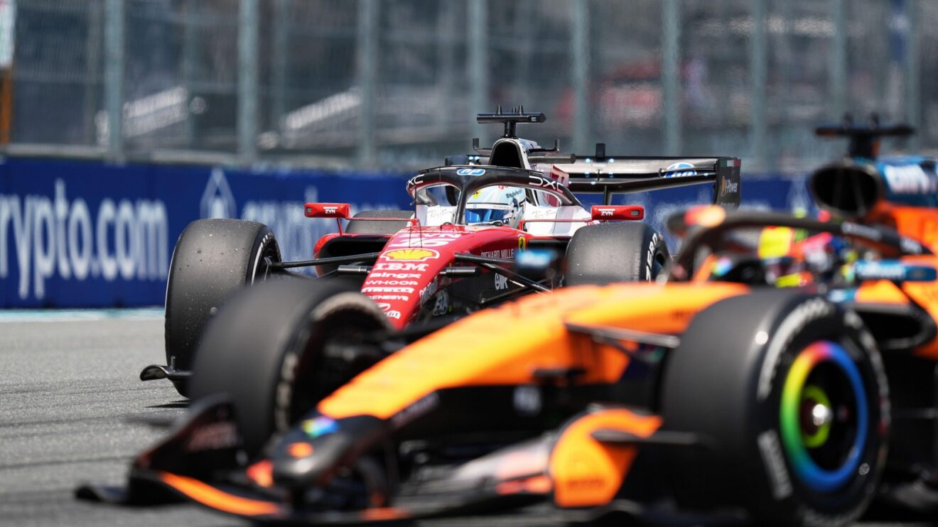 Charles Leclerc approaches Oscar Piastri on track in Miami, the McLaren out of focus in the foreground with Leclerc's Ferrari sharp in the background.