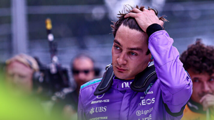 George Russell runs his fingers through his hair having just climbed from his car and taken his helmet off.